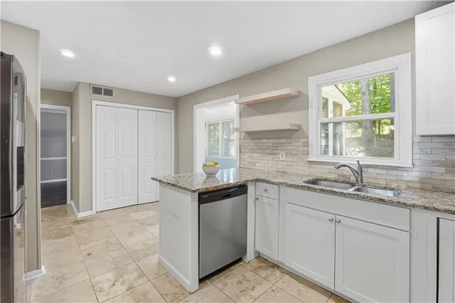 a kitchen with granite countertop a sink and cabinets