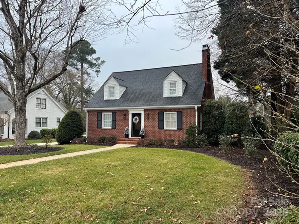 a front view of a house with a yard and trees