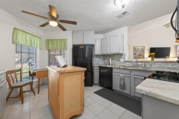 a kitchen with stainless steel appliances granite countertop a stove a sink a refrigerator and island