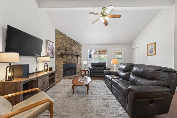 a living room with furniture a fireplace and a flat screen tv