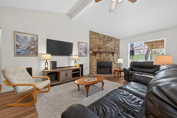 a living room with furniture a flat screen tv and a fireplace