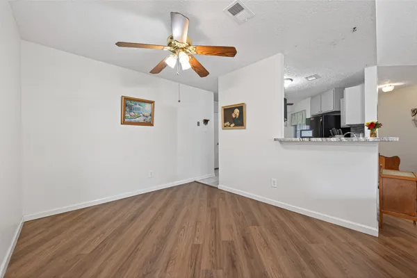 a view of a kitchen with wooden floor and a ceiling fan