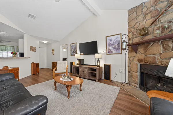 a living room with furniture a fireplace and a flat screen tv