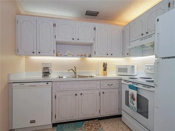 a kitchen with cabinets appliances and a sink