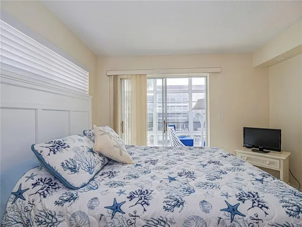 a bedroom with a bed and large window