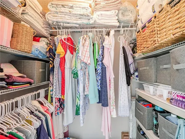 a view of walk in closet with clothes and shoes