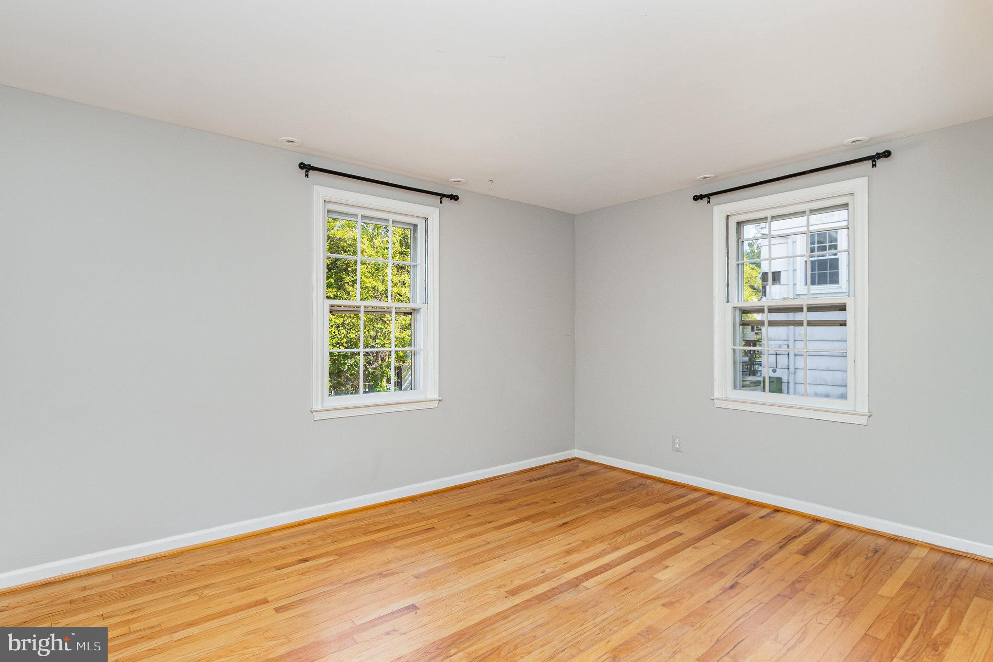 2304 Pickwick Road Baltimore, MD 21207 - Photo 17 of 37 a view of an empty room with wooden floor and a window