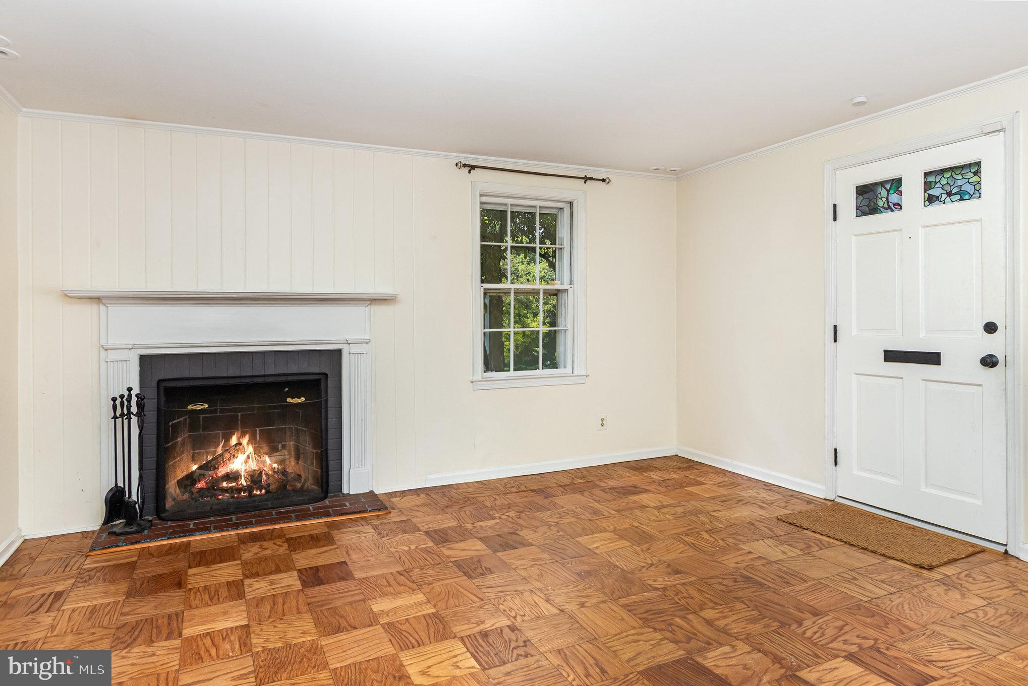 2304 Pickwick Road Baltimore, MD 21207 - Photo 8 of 37 a view of an empty room with a fireplace and window