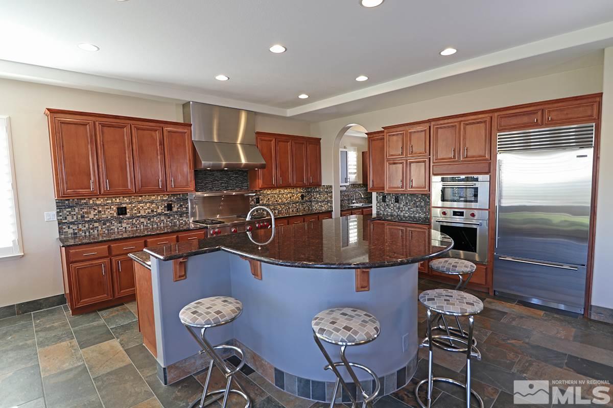 2655 Strathmore Court Reno, NV 89521 - Photo 4 of 38 a kitchen with stainless steel appliances granite countertop a sink a stove a refrigerator cabinets and chairs