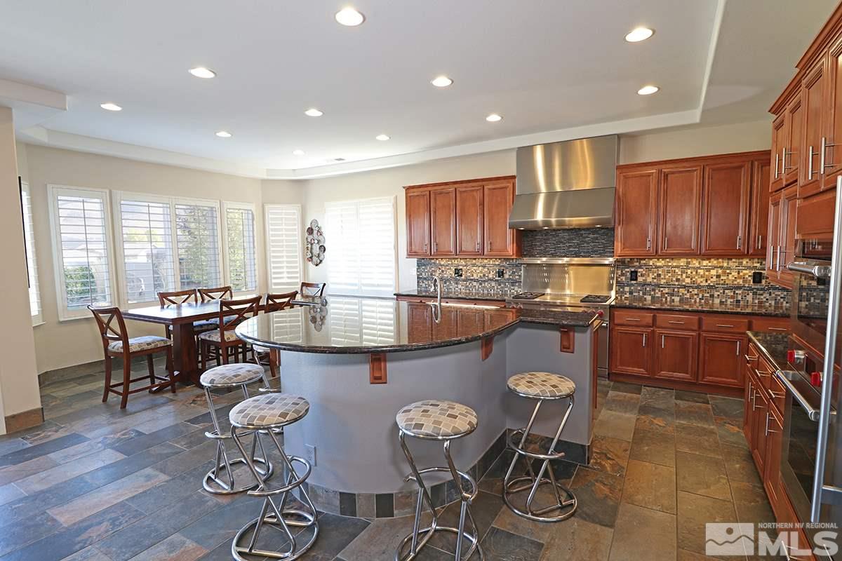 2655 Strathmore Court Reno, NV 89521 - Photo 5 of 38 a kitchen with a table chairs stove and microwave