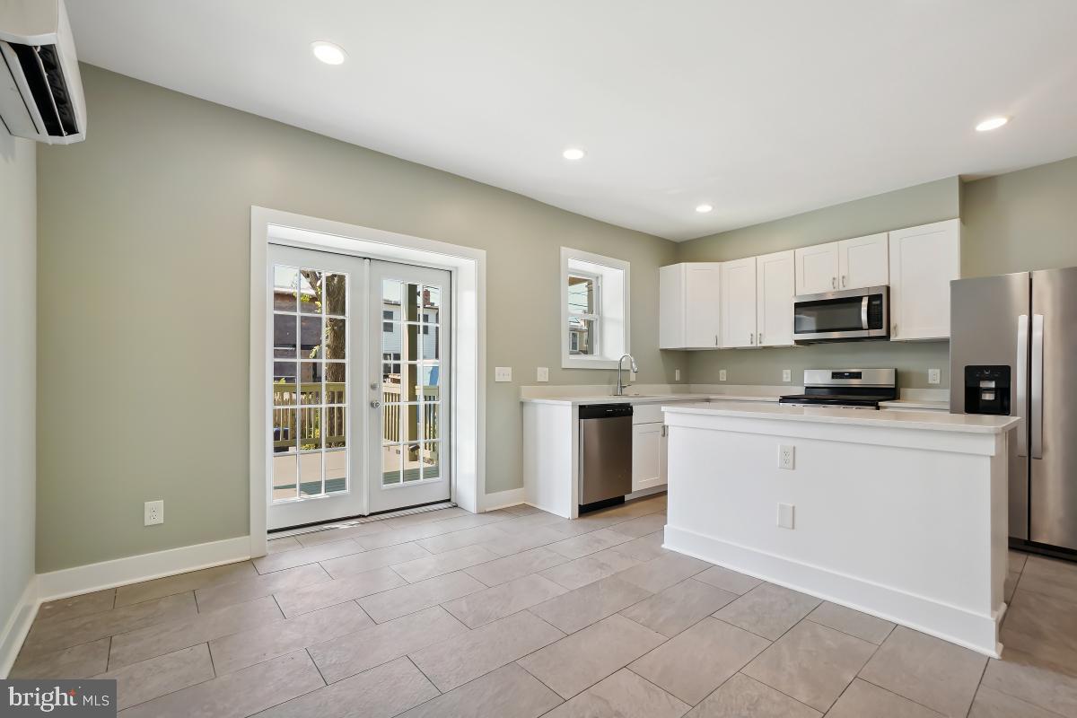 37 Michigan Avenue Northeast Washington, DC 20002 - Photo 11 of 31 a kitchen with stainless steel appliances granite countertop a stove top oven a sink a refrigerator and white cabinets with wooden floor