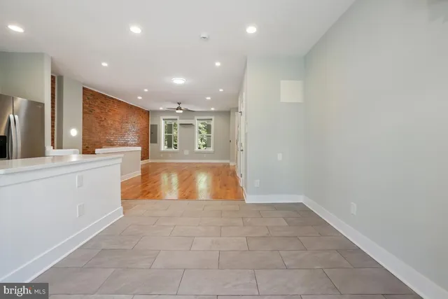 a large space with kitchen island a sink a counter top space and stainless steel appliances