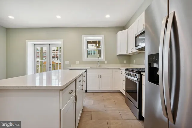 a kitchen with stainless steel appliances granite countertop a refrigerator sink and stove