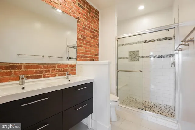 a bathroom with a shower sink and mirror