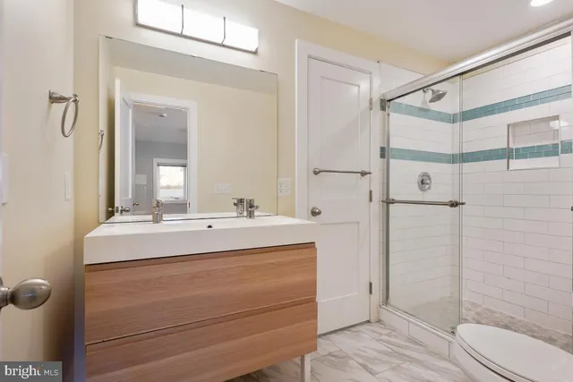 a bathroom with a sink and mirror with toilet