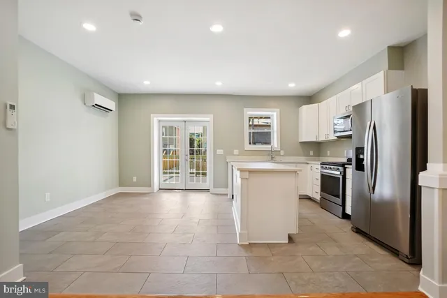 a kitchen with a refrigerator and a stove top oven