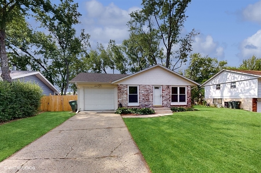 2321 Spring Hill Lane Lindenhurst, IL 60046 - Photo 2 of 30 a front view of a house with a yard and trees