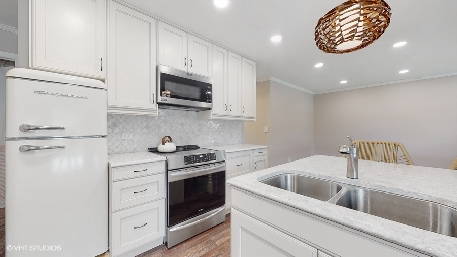 2321 Spring Hill Lane Lindenhurst, IL 60046 - Photo 10 of 30 a kitchen with white cabinets and appliances