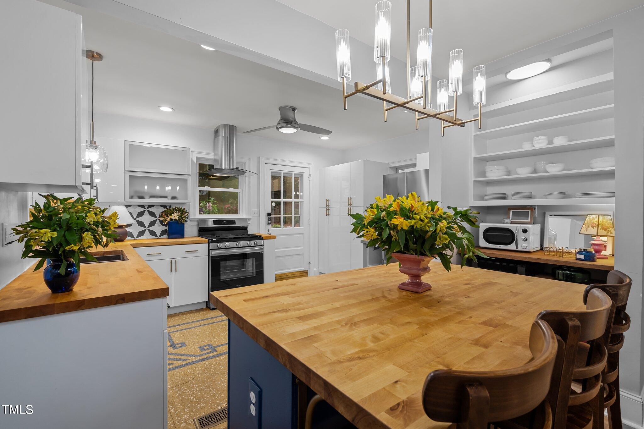 3215 Merriman Avenue Raleigh, NC 27607 - Photo 18 of 66 a kitchen with kitchen island a chandelier and living room view
