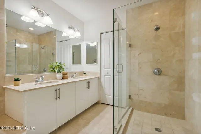 a bathroom with a shower sink vanity mirror and toilet