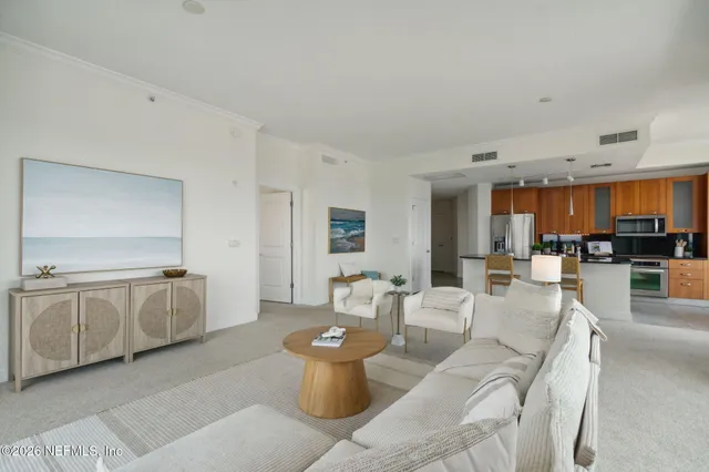 a kitchen with stainless steel appliances granite countertop a stove a refrigerator a sink a dining table and chairs with wooden floor