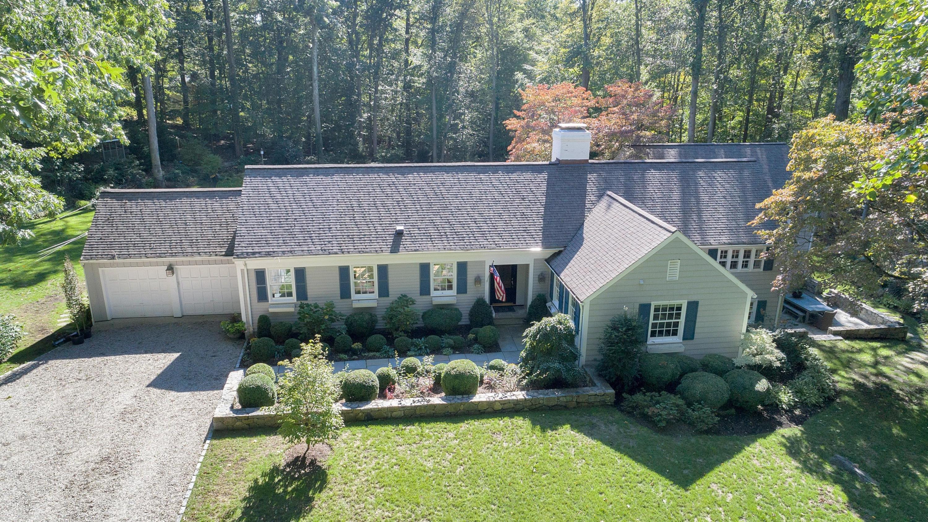 44 Deepwood Road Darien, CT 06820 - Photo 2 of 45 a front view of a house with a yard table and chairs