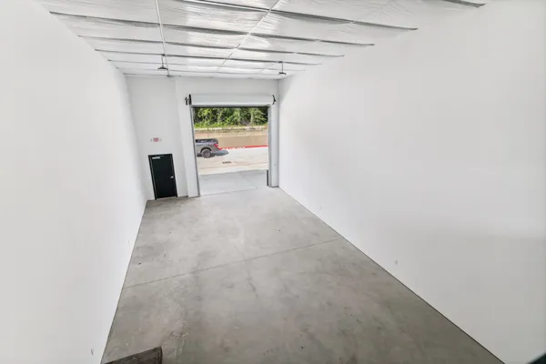 a view of a hallway with a white cabinet and a refrigerator