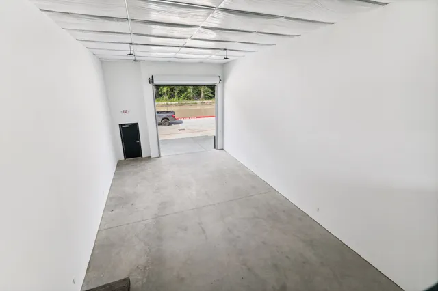 a view of a hallway with a white cabinet and a refrigerator