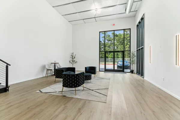 a living room with furniture large window and wooden floor