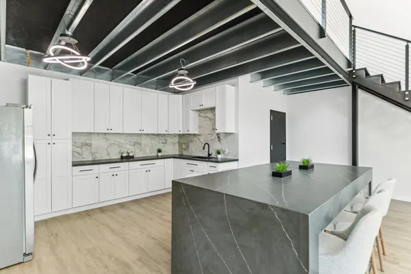 a kitchen with stainless steel appliances granite countertop a sink a stove and cabinets