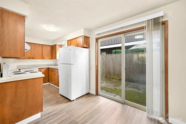 a kitchen with granite countertop a refrigerator a sink and a stove top oven