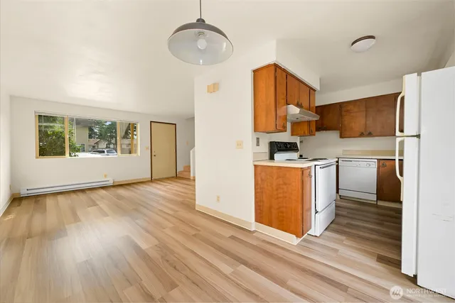 a kitchen with stainless steel appliances granite countertop a refrigerator a stove and a wooden floors