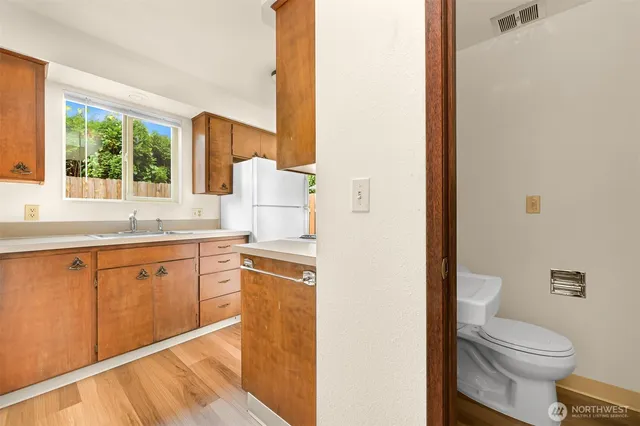 a spacious bathroom with a granite countertop sink toilet and large mirror