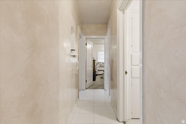 348 East 200 North Logan, UT 84321 - Photo 25 of 41 Hallway featuring light-toned walls, white tile flooring, and white trim