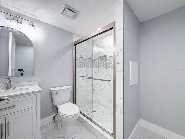 a bedroom with a bed a mirror and a window