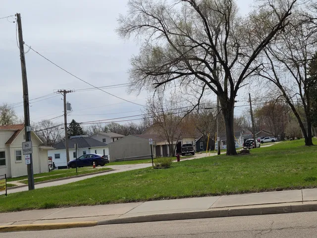 a view of a big house with a big yard and large trees