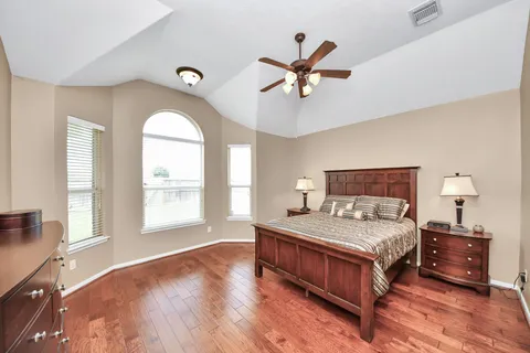 a bedroom with a bed and wooden floor