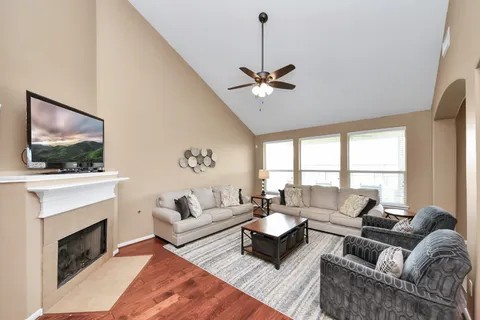 a living room with furniture a fireplace and a flat screen tv