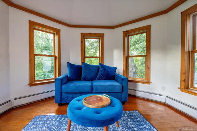 a living room with furniture a fireplace and large windows
