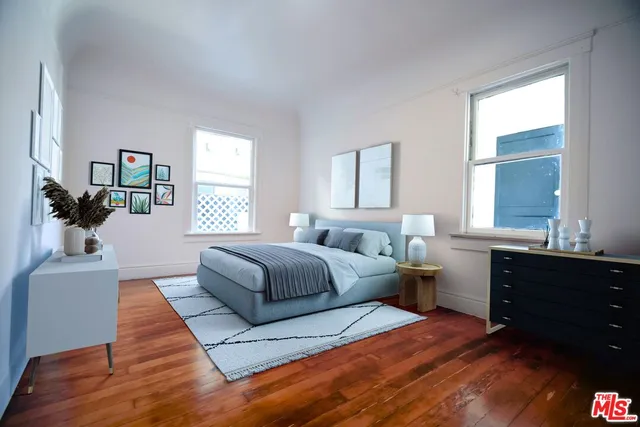 a spacious bedroom with a bed and a dresser next to a window