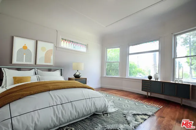 a bedroom with a bed and a large window