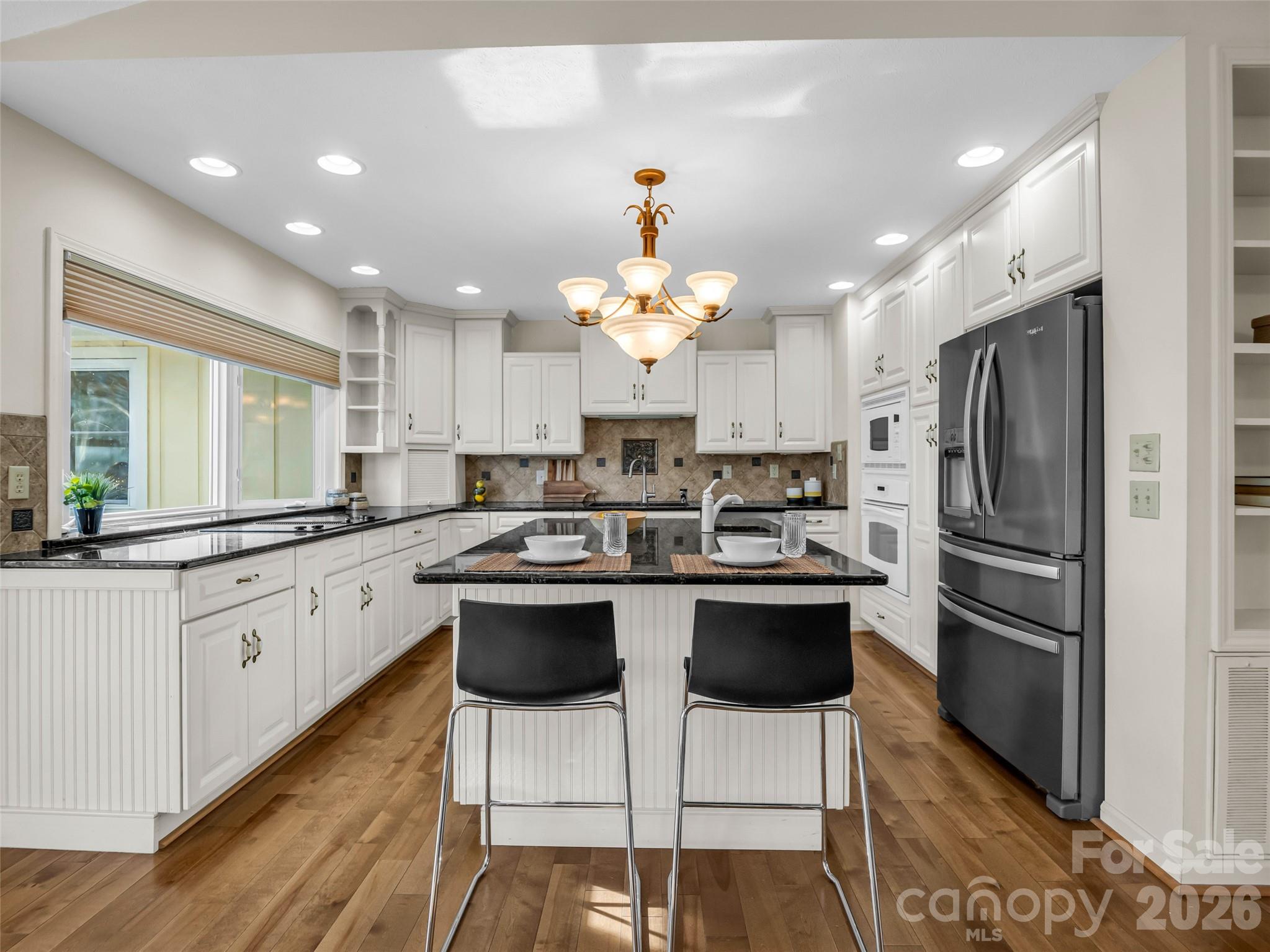 1594 Indian Cave Road Hendersonville, NC 28739 - Photo 15 of 48 a kitchen with granite countertop a white refrigerator a sink island and chairs