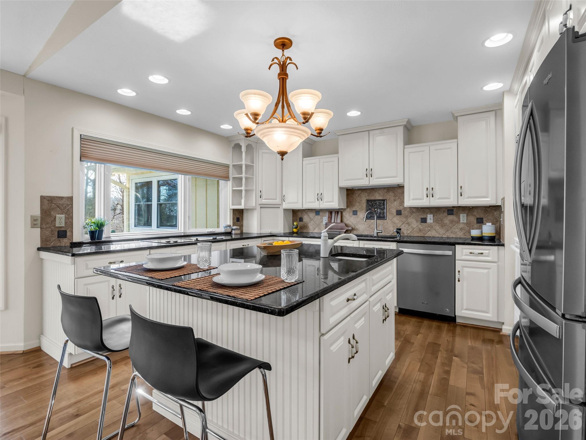 1594 Indian Cave Road Hendersonville, NC 28739 - Photo 16 of 48 a kitchen with stainless steel appliances granite countertop a sink a stove a refrigerator and island with wooden floor