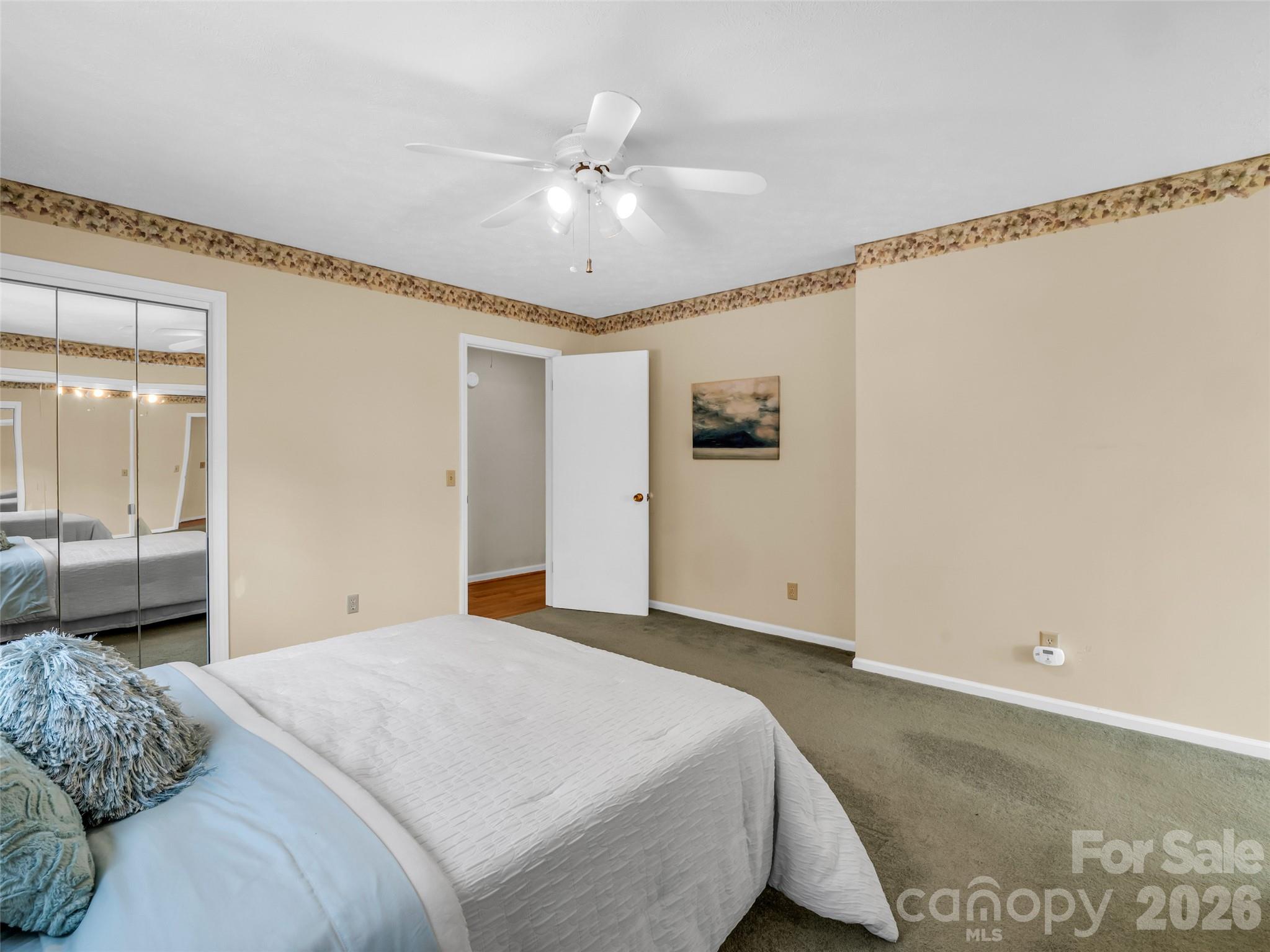 1594 Indian Cave Road Hendersonville, NC 28739 - Photo 23 of 48 a bedroom with a large bed and chandelier fan