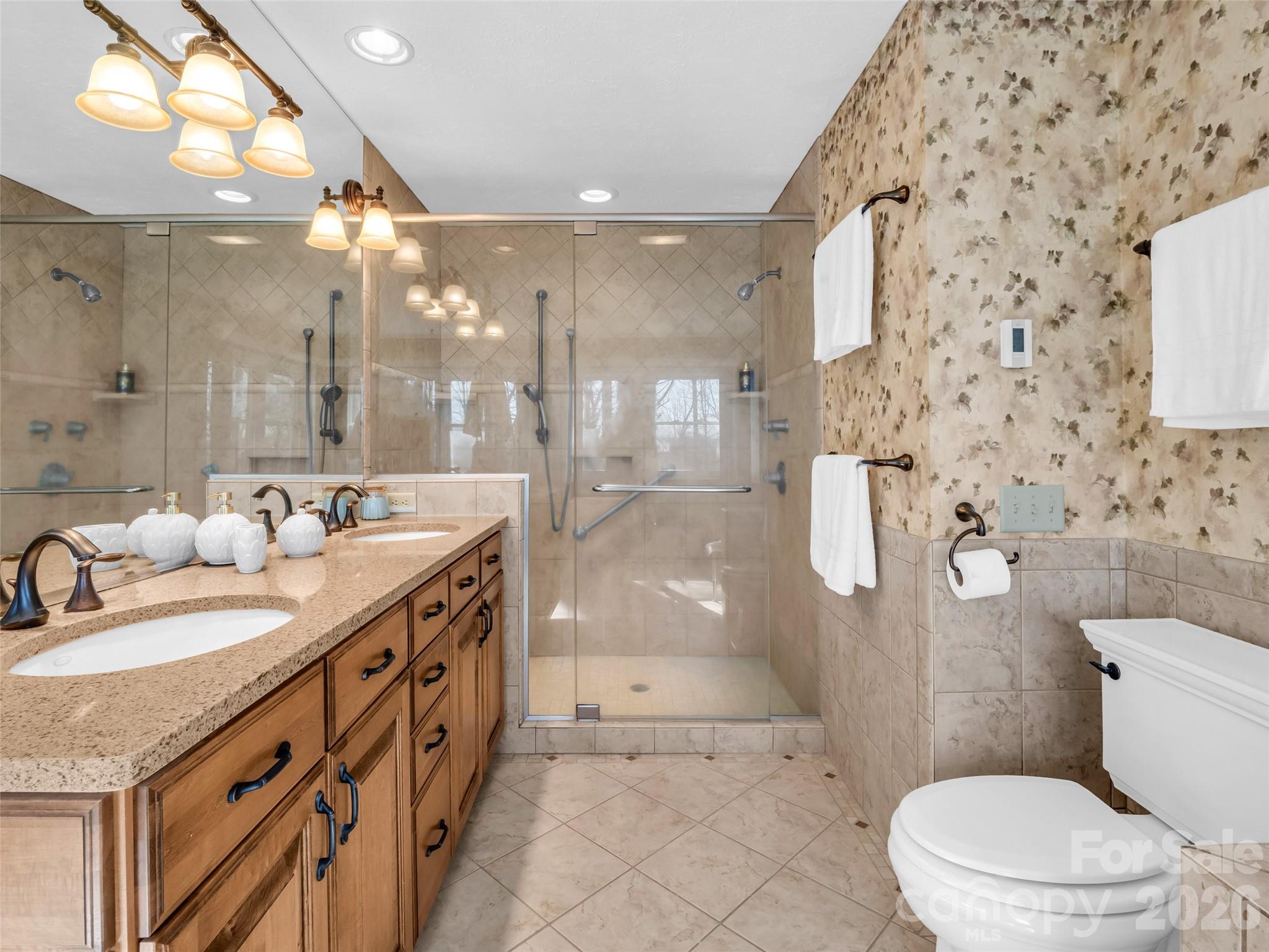 1594 Indian Cave Road Hendersonville, NC 28739 - Photo 26 of 48 a bathroom with a granite countertop sink a toilet a mirror and shower