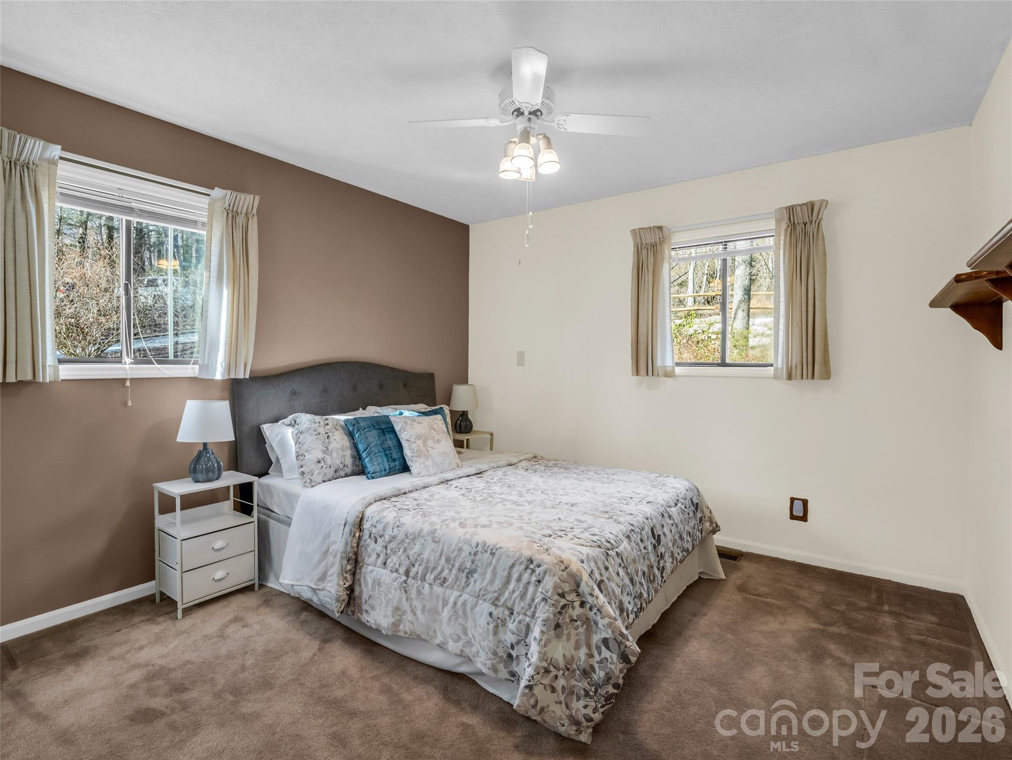 1594 Indian Cave Road Hendersonville, NC 28739 - Photo 29 of 48 a bedroom with a large bed and a chandelier