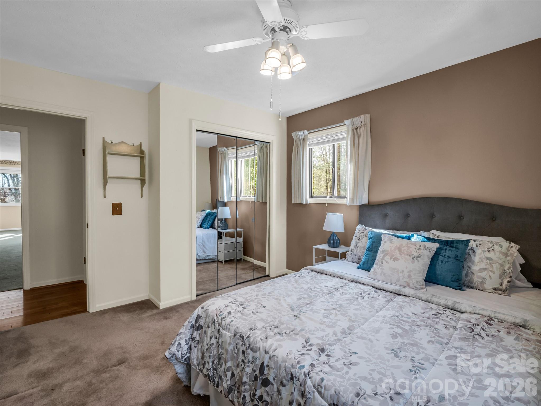 1594 Indian Cave Road Hendersonville, NC 28739 - Photo 30 of 48 a bedroom with a large bed and a chandelier