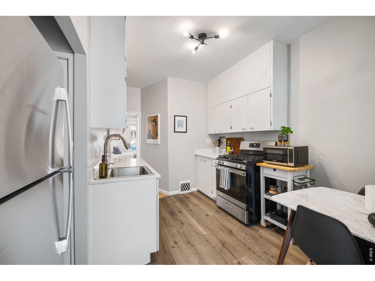 1070 Cook Street Denver, CO 80206 - Photo 9 of 35 a kitchen with kitchen island a stove a sink and a refrigerator