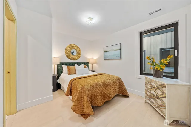 a bedroom with a bed and painting on the wall