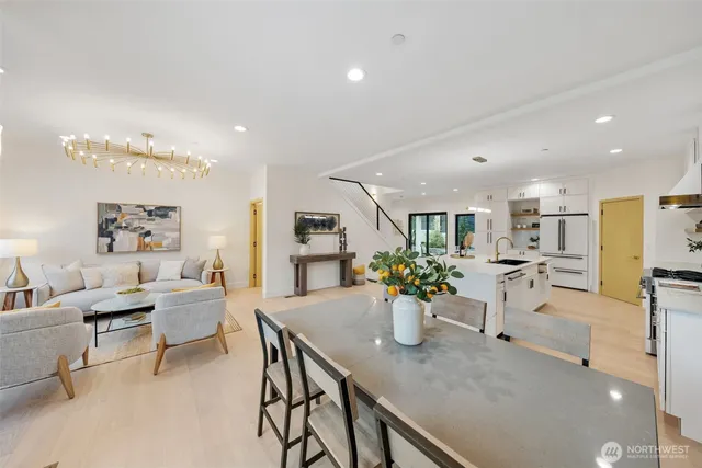 a view of a dining room and livingroom with furniture a rug a potted plant and a fireplace